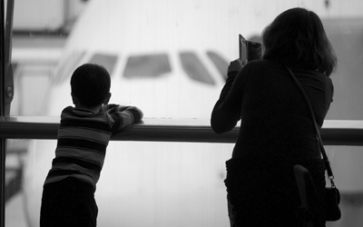 Woman and child watching plane at gate in airport